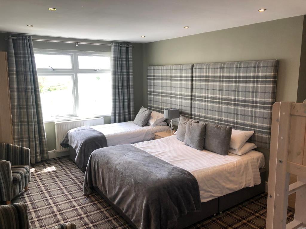 a hotel room with two beds and a window at The Sunningdale in Bamburgh