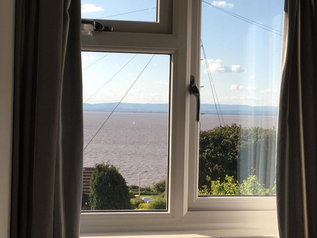 een raam met uitzicht op de oceaan bij The Nook @ Drop Anchor in Portishead