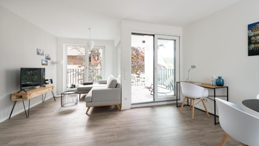 a white living room with a couch and a tv at Ferienwohnung Universität in Tübingen