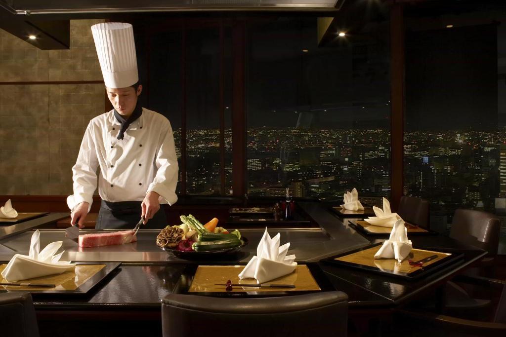 a chef preparing food at a table in a restaurant at Nagoya Marriott Associa Hotel in Nagoya