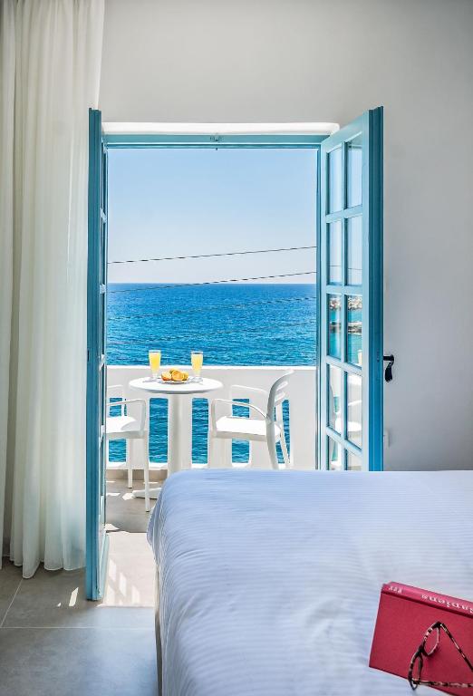 a bedroom with a bed and a view of the ocean at Livikon by the Sea in Hora Sfakion