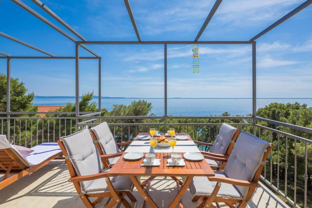 a table and chairs on a balcony with a view of the ocean at Apartments Silvana in Sveta Nedelja
