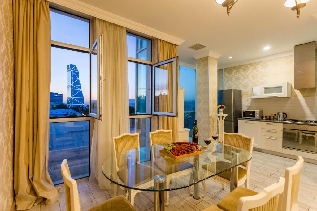 a kitchen and dining room with a glass table and chairs at Tbilisi Apartment in Tbilisi City