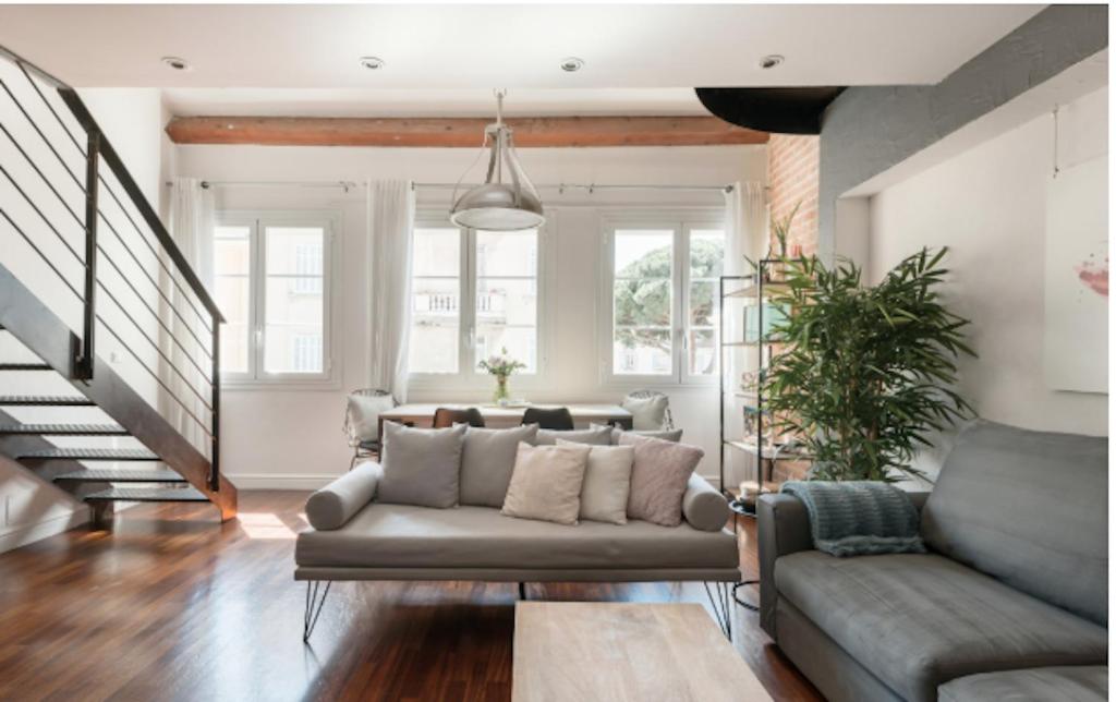 un salon avec un canapé et un escalier dans l'établissement Central Cannes Loft - 15 min Palais des Festivals, à Cannes