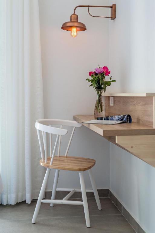 a white chair sitting next to a counter with a vase of flowers at Livikon by the Sea in Hora Sfakion