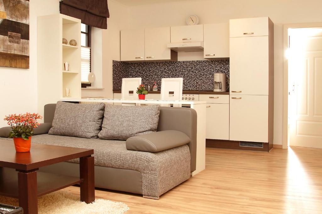 ein Wohnzimmer mit einem Sofa und einer Küche in der Unterkunft Ferienwohnung Am Turm in Bad Staffelstein
