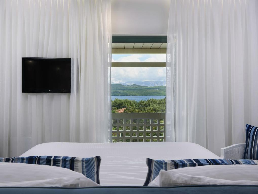 ニキアナにあるThomais Boutique Hotelのベッドが2つと窓があるホテルの部屋