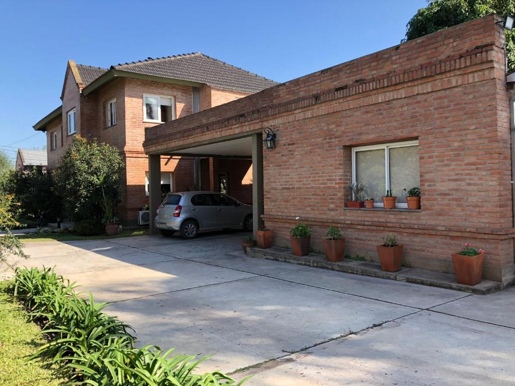 a brick house with a car parked in the garage at Departamento pie del cerro in Yerba Buena