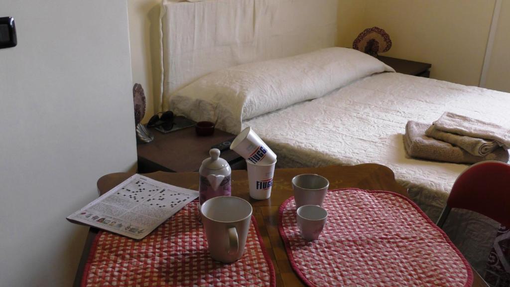 um quarto com uma cama e uma mesa de madeira com chávenas em Studio Liberty em Fiuggi