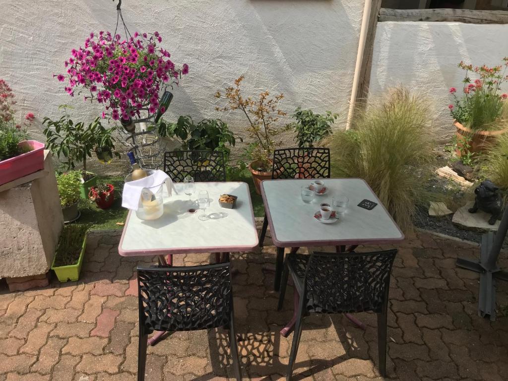 une table avec deux chaises et une table avec une tasse de thé dans l'établissement La Bonne Franquette, à Noizay