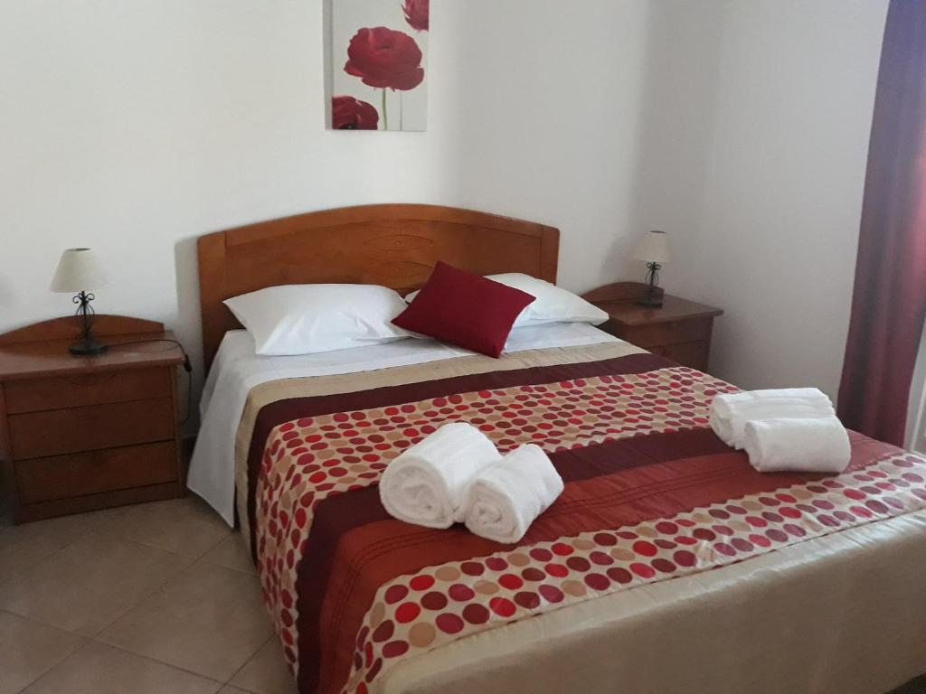 ein Schlafzimmer mit einem Bett mit Handtüchern darauf in der Unterkunft Casa da Zi in Vila Nova de Milfontes
