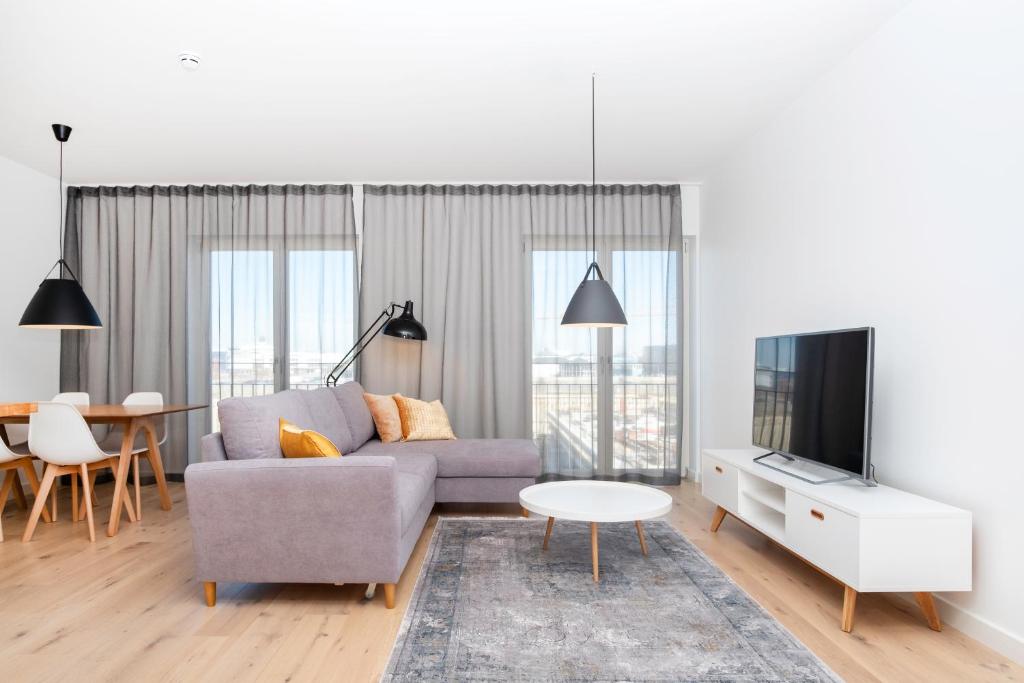 un soggiorno con divano, TV e tavolo di Dream Stay - 2 Porto Franco Apartments near Old Town a Tallinn