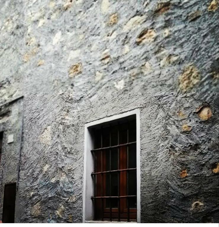 uma janela no lado de um edifício de pedra em Le Lanterne em Albavilla