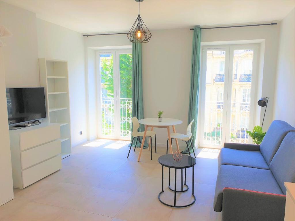 un salon avec un canapé bleu et une table dans l'établissement STUDIO CENTRE MER 302, à Nice