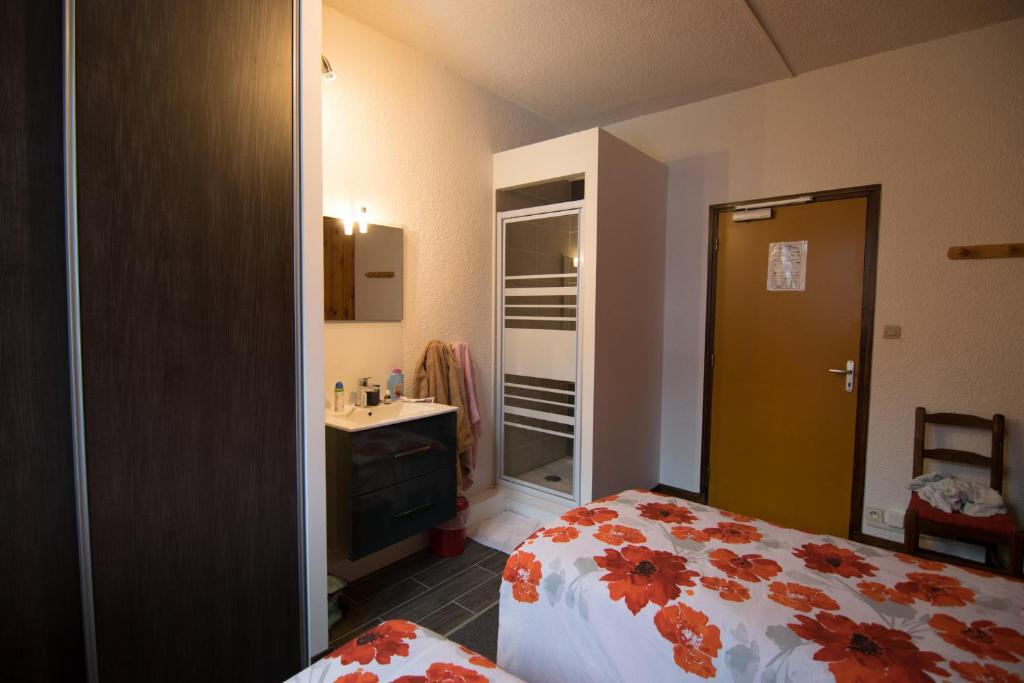 a bedroom with a bed and a bathroom with a sink at GITE LES GUIBERTES in Le Monêtier-les-Bains