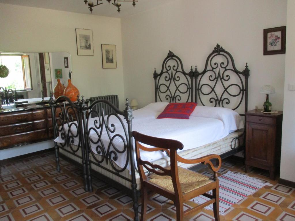 a bedroom with a black and white bed and a chair at Emeroteca del '900 in Casalborgone