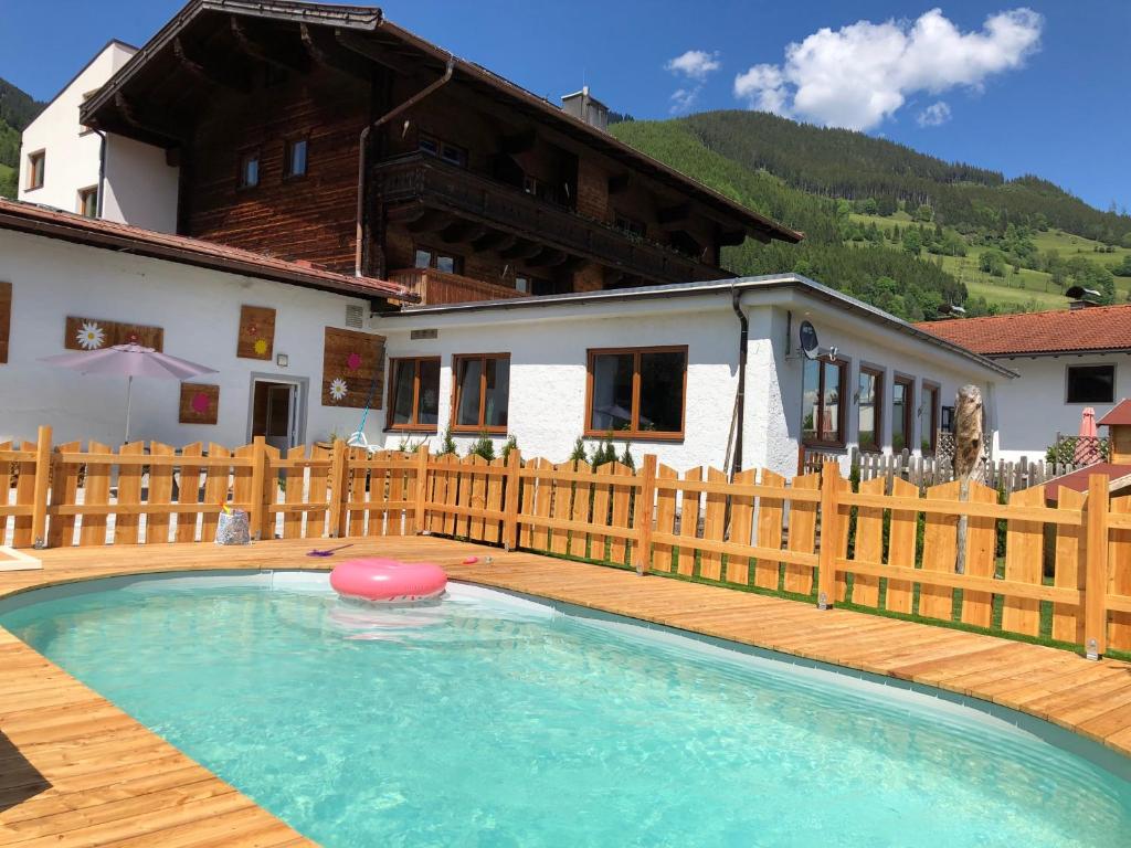 a swimming pool with a frisbee in front of a house at Apartments Chalet Sonnentanz in Piesendorf