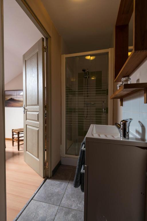 a kitchen with a sink and a door to a room at B&B Les Trois Voisins in Bourseigne-Vieille