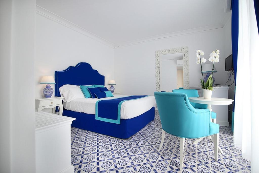 a bedroom with a bed and a table and chairs at Hotel Marincanto in Positano