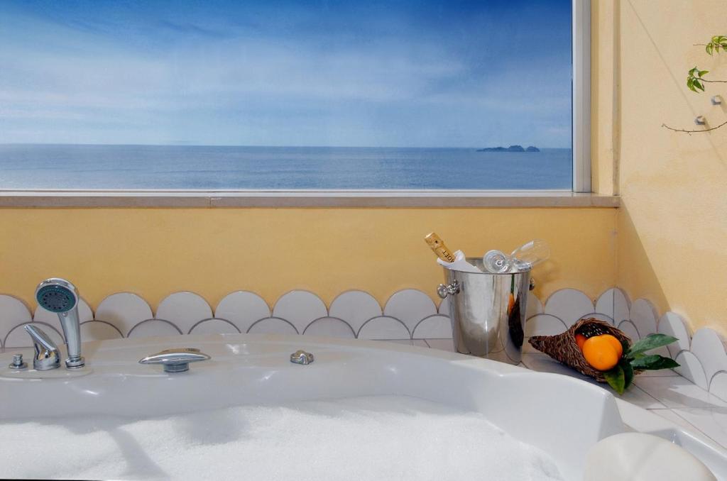 a bathroom with a sink and a window with an ocean at Hotel Marincanto in Positano