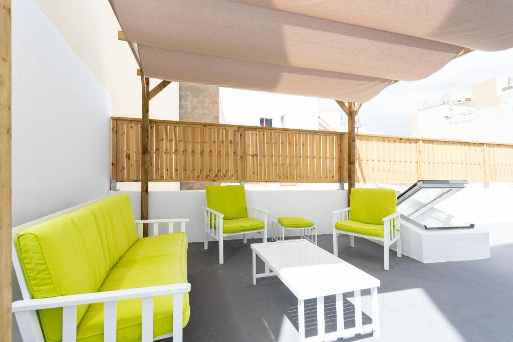 balcón con mesa y sillas verdes y blancas en The wave house El Médano, en El Médano