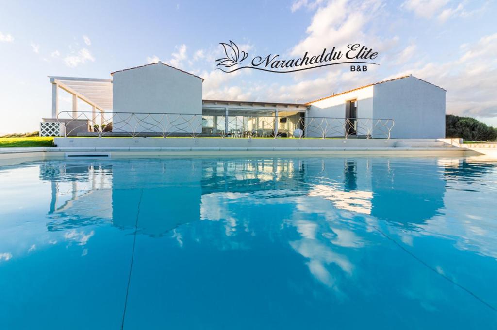 una grande piscina di fronte a un edificio di B&B Naracheddu Elite a Santa Teresa di Gallura