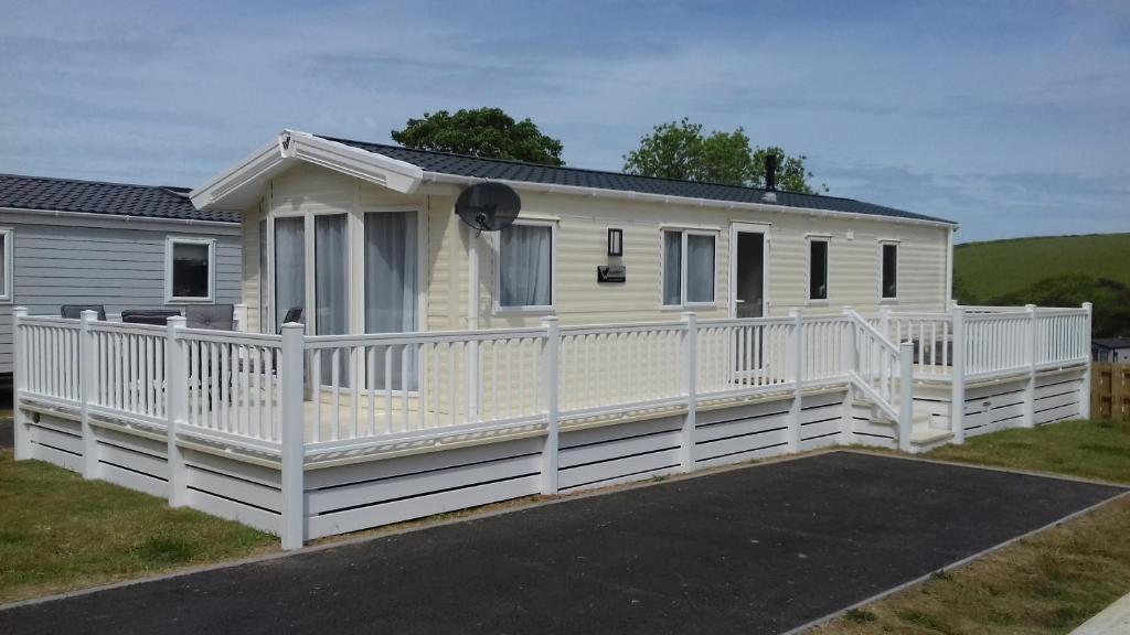 uma casa móvel branca com uma cerca branca em Porth Retreat at Newquay Bay Resort em Newquay