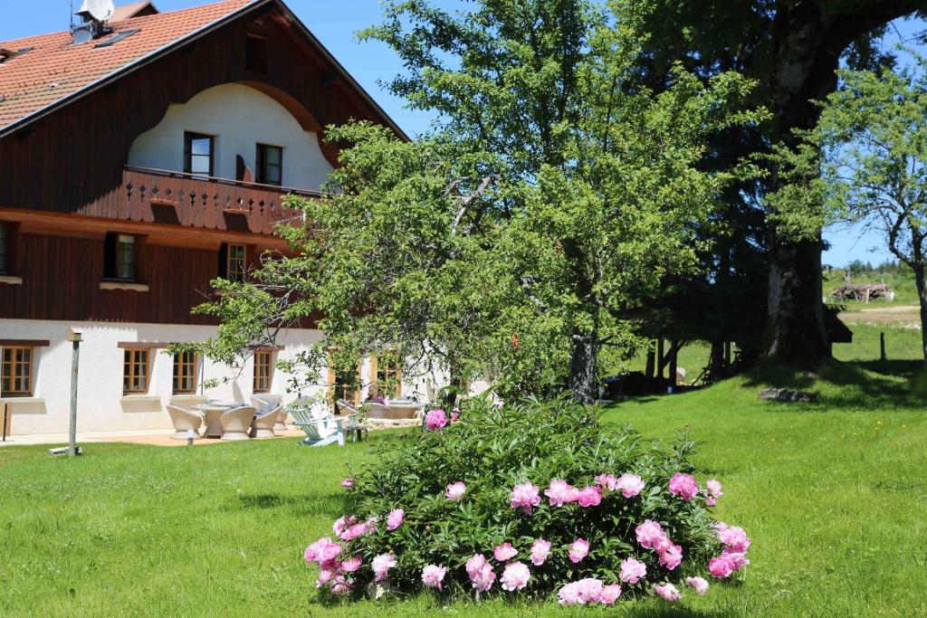 una casa con un ramo de flores en el patio en Le Tillau, en Les Verrières-de-Joux