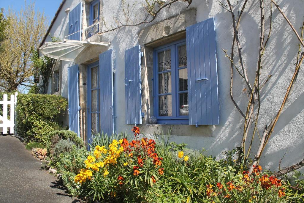 una ventana azul y flores fuera de una casa en LA MAISON BLEUE, en Saint-Gelais