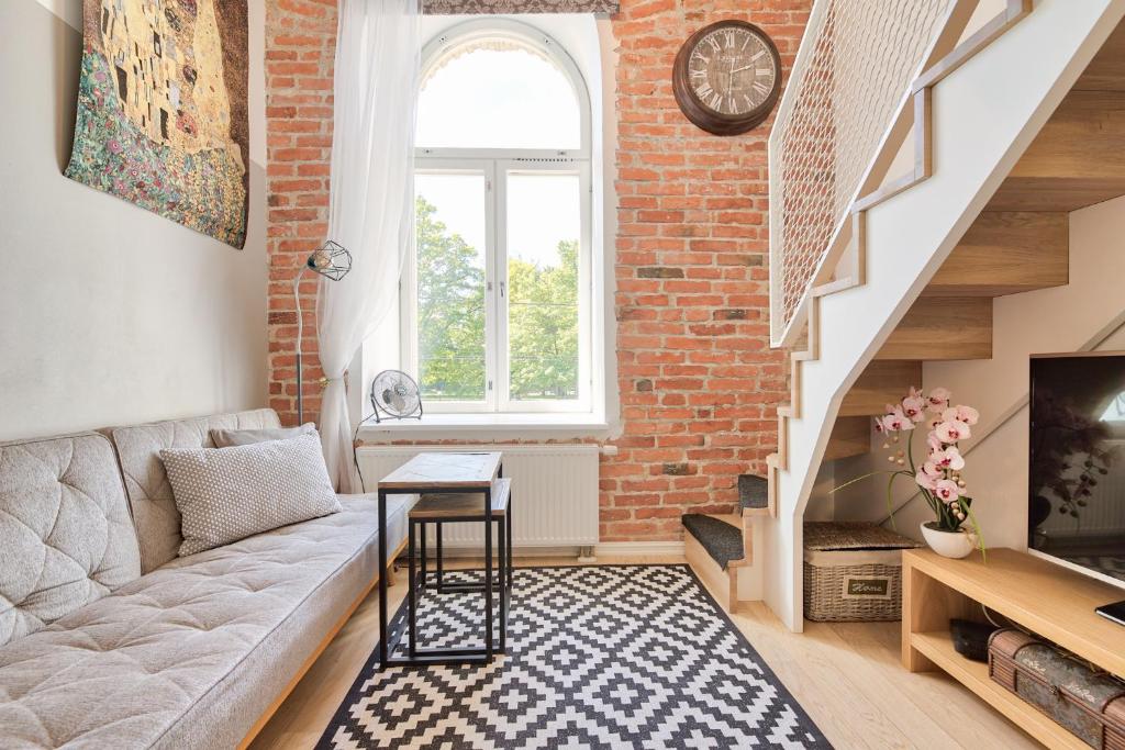 een woonkamer met een bank en een bakstenen muur bij Rotermann City Apartments in Tallinn