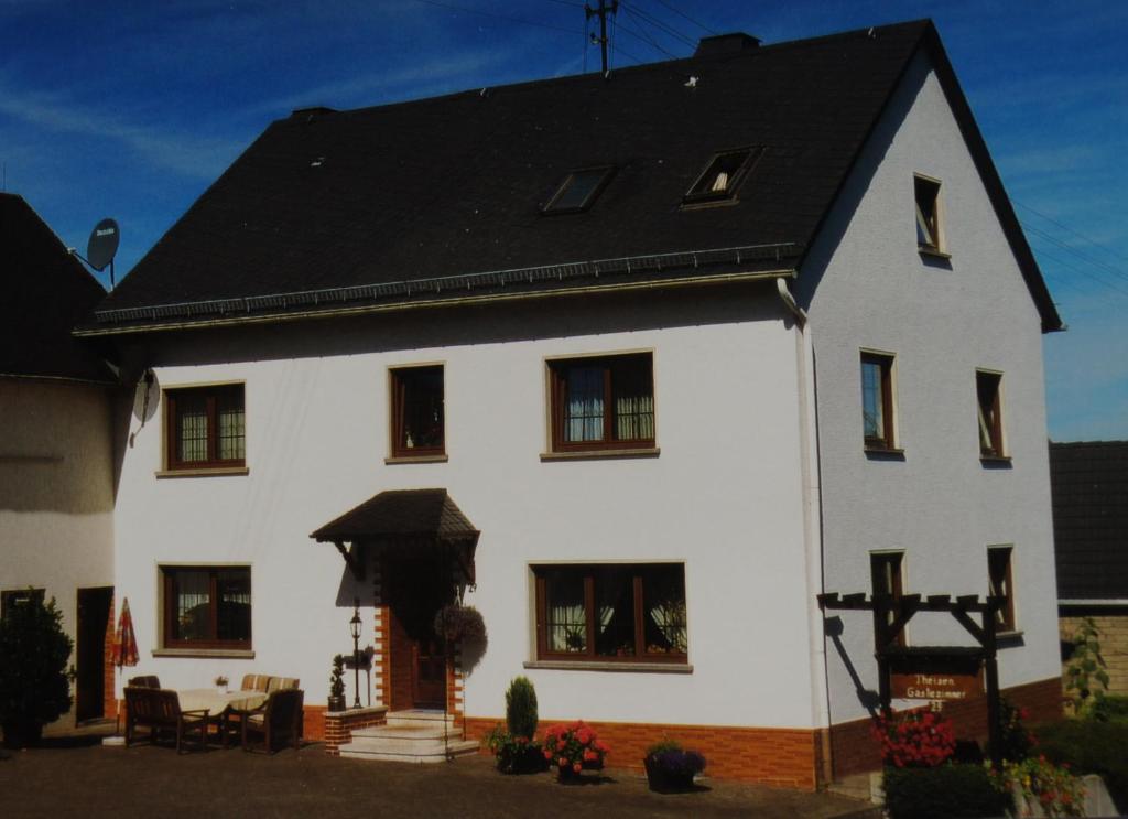 a white house with a black roof at Pension Loni Theisen in Kelberg