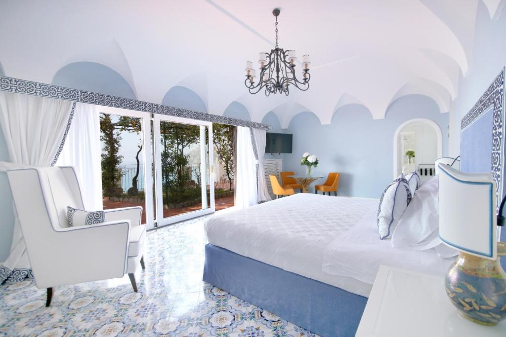 a bedroom with a bed and a table and chairs at Hotel Marincanto in Positano