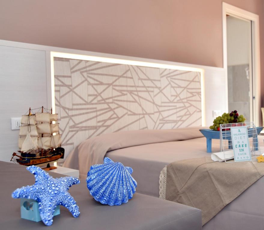 a bedroom with a bed and two starfish on a table at Hotel Maioli in Misano Adriatico