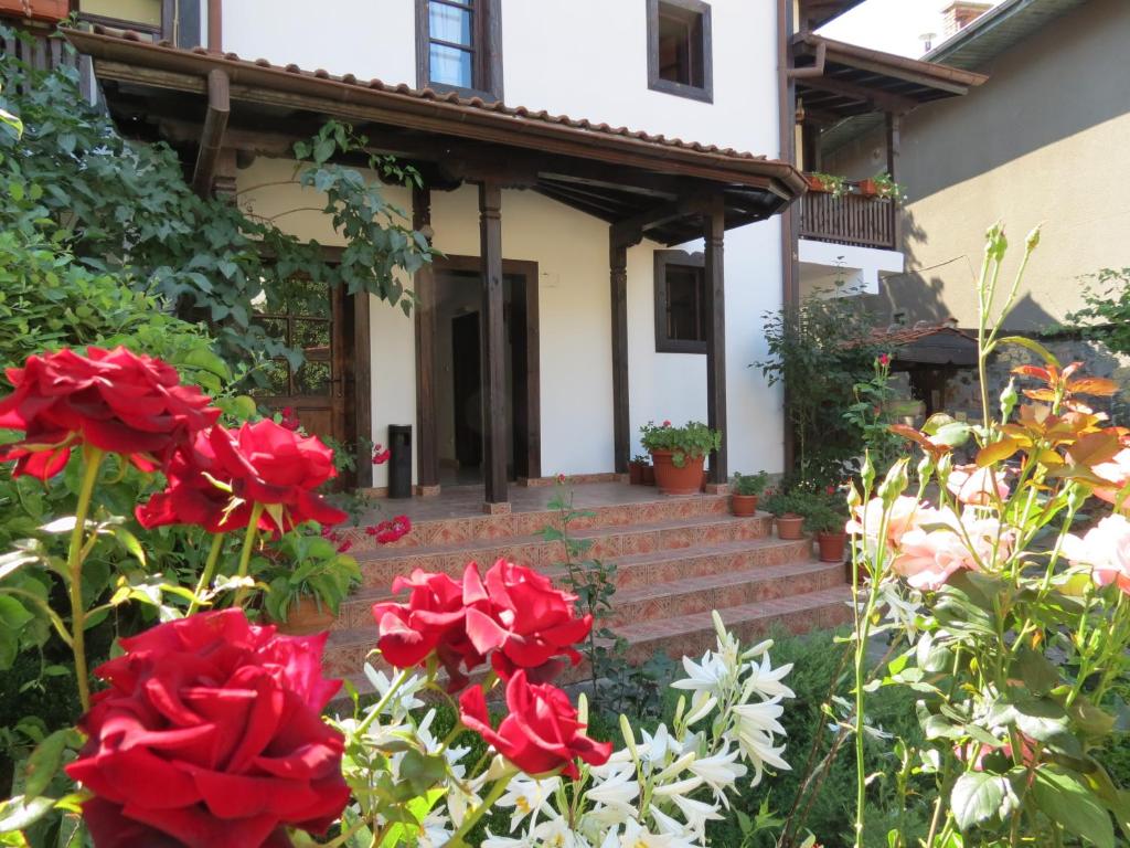 una casa con rose rosse nel giardino anteriore di Oazis Guesthouse a Lovech