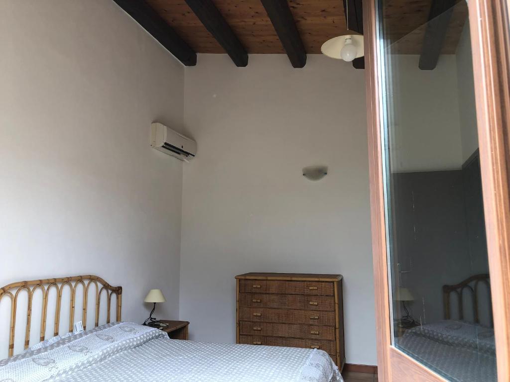 a bedroom with a mirror and a bed and a dresser at L'uliveto sul mare - Libeccio in Fontane Bianche