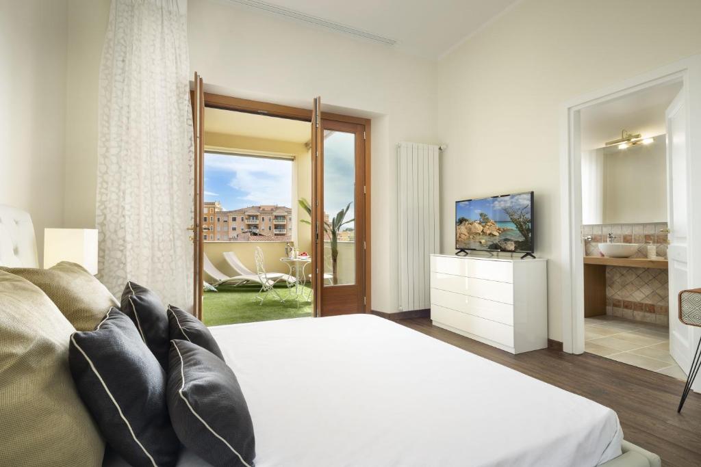 a bedroom with a bed and a sliding glass door at Luxury Rooms & Suites in Olbia