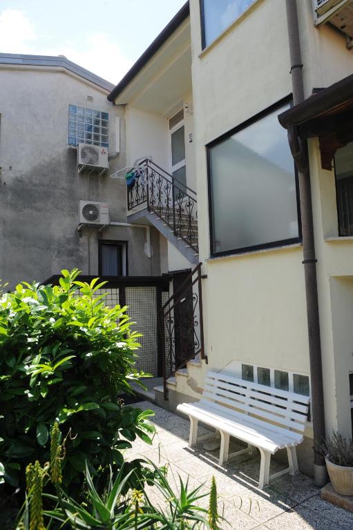 een witte bank voor een gebouw bij Apartma LaVela in Izola