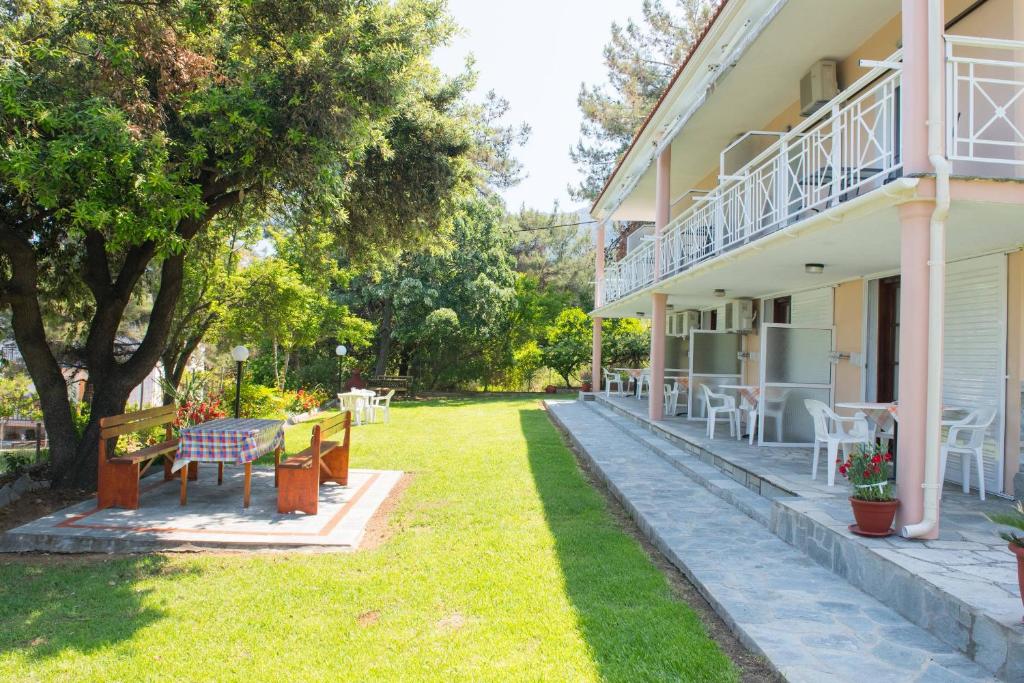 una casa con cortile dotato di panchine e tavoli di Pension Giannis Αdults only a Kinira