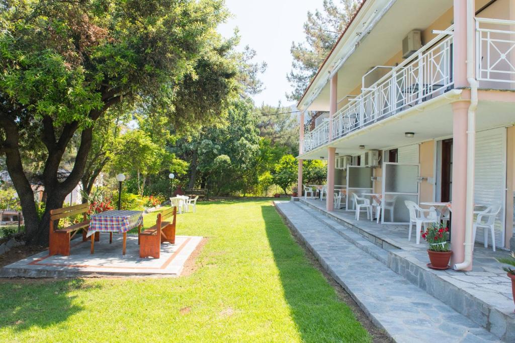 una casa con un patio con bancos y mesas en Pension Giannis Αdults only, en Koinira