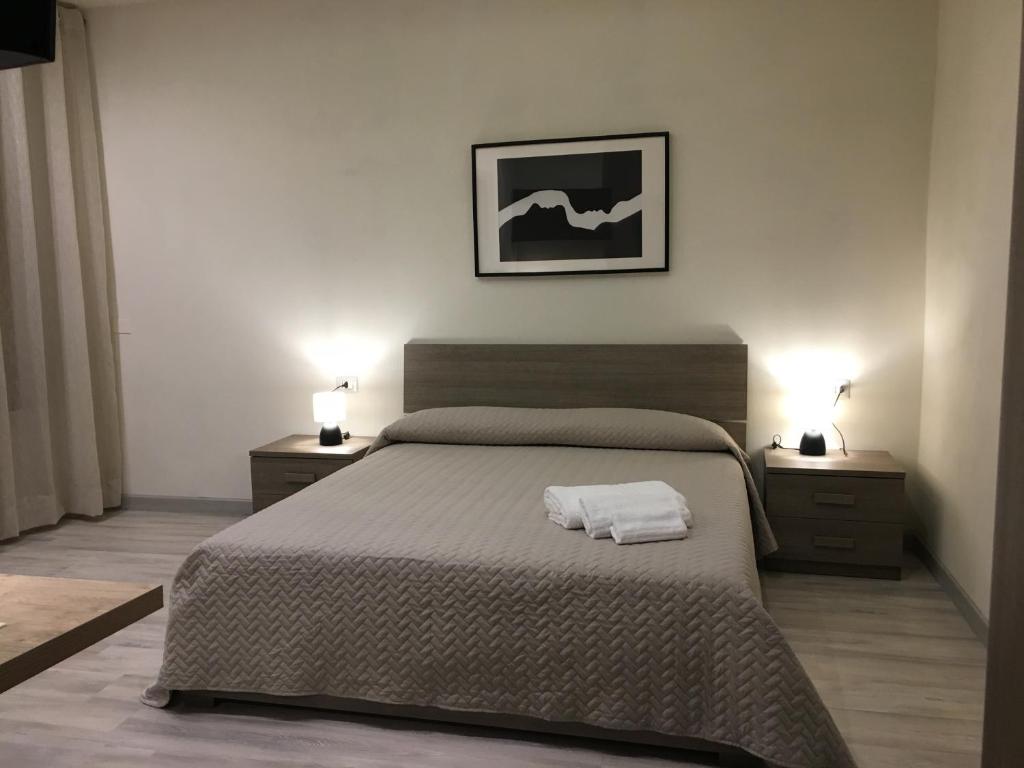 una camera da letto con un grande letto con due comodini di Dimora Conte a La Maddalena