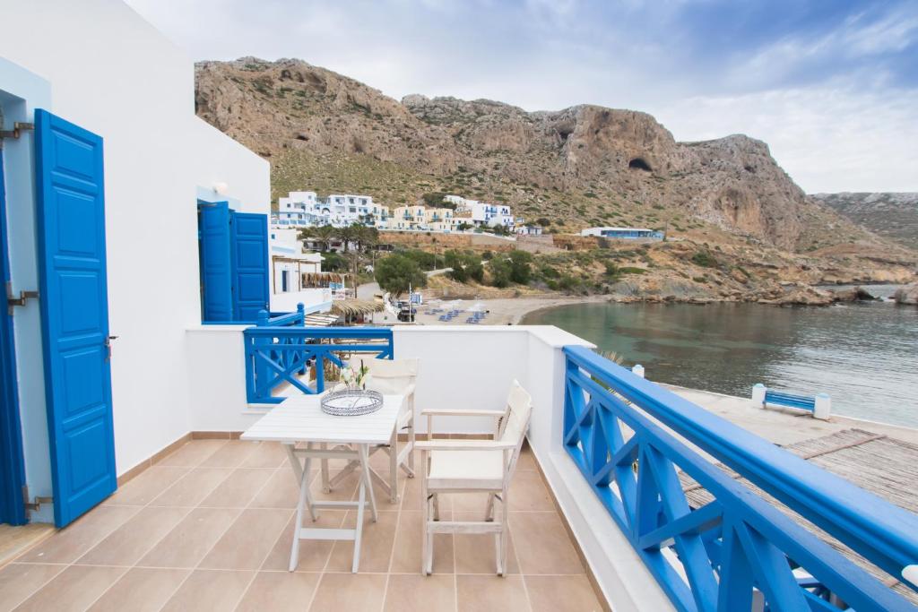 a balcony with a table and chairs and a view of the water at Poseidon Luxury Apartment in Karpathos Town
