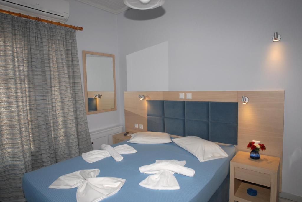 una camera da letto con un letto blu e asciugamani di Irene ROOMS & STUDIOS PETRA a Pétra