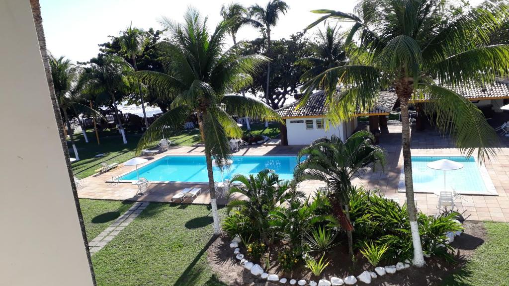an aerial view of a resort pool with palm trees at Apart Condomínio Jubiabá in Ilhéus