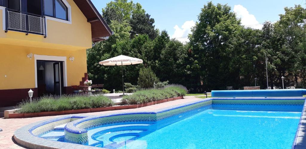 a swimming pool in front of a house at Schieszl Apartments Zamárdi 1 in Zamárdi