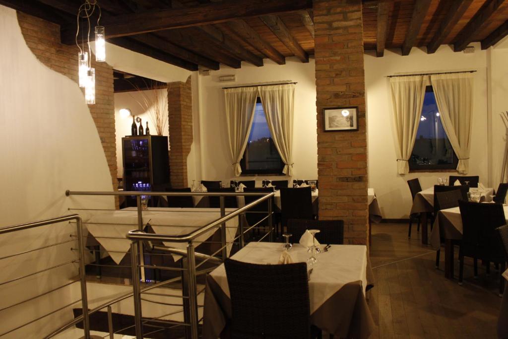 jadalnia ze stołami, krzesłami i oknami w obiekcie Hotel La Vecchia Reggio w mieście Reggio nell'Emilia