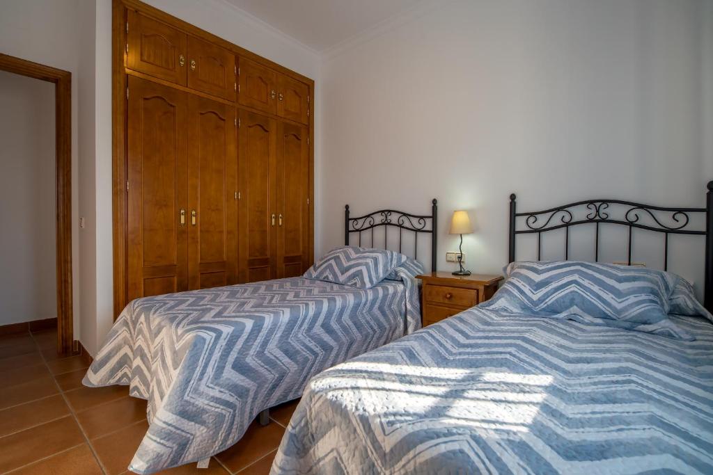 Łóżko lub łóżka w pokoju w obiekcie Chalet adosado Atalaya P