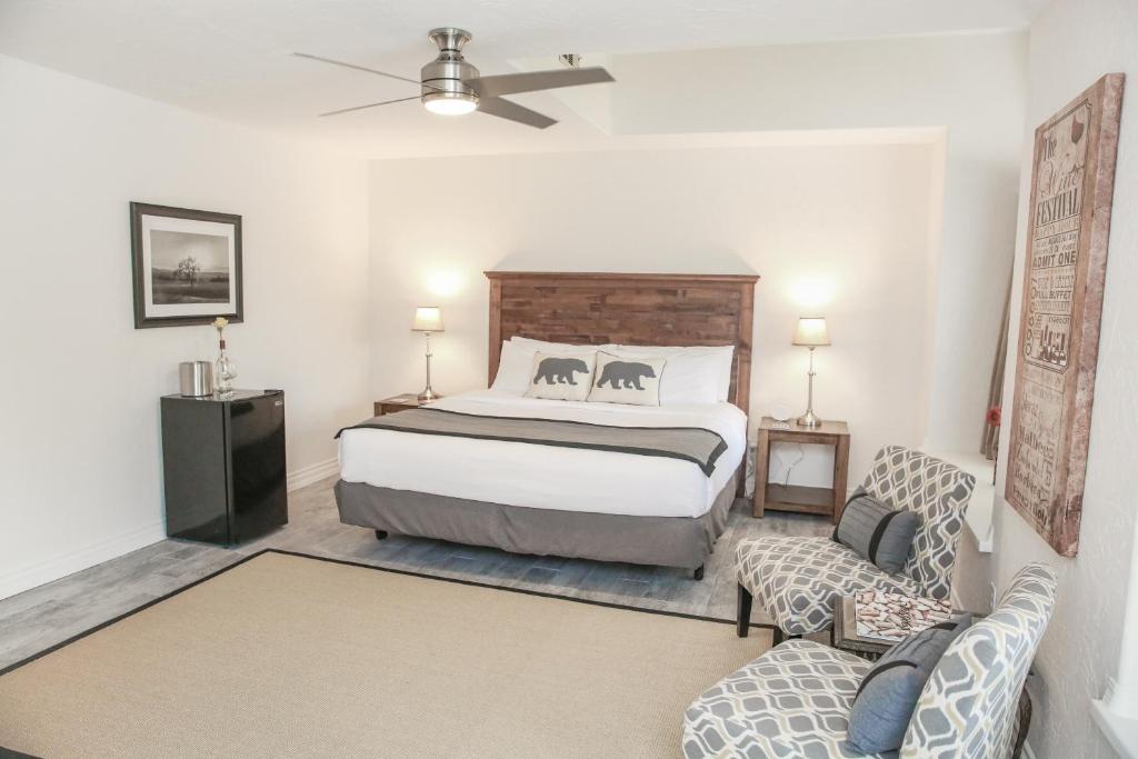 a bedroom with a bed and a couch and a chair at The Eden House Vineyard in Templeton