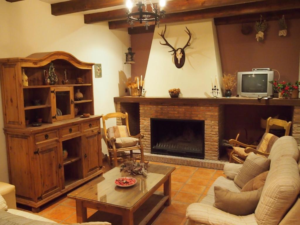 Vivienda Turística Rural Casa Camilo في سيغورا دي لا سييرا: غرفة معيشة مع أريكة ومدفأة