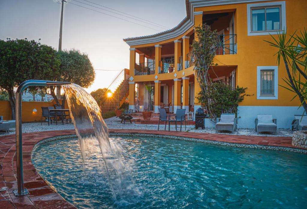 a pool with a water fountain in front of a house at Moonshine Studios Lagos in Lagos