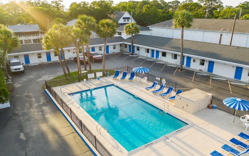 an overhead view of a swimming pool with chairs and umbrellas at Royal Palms Motel in Tybee Island
